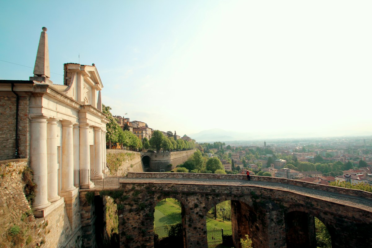 Historic buildings among green trees in Bergamo