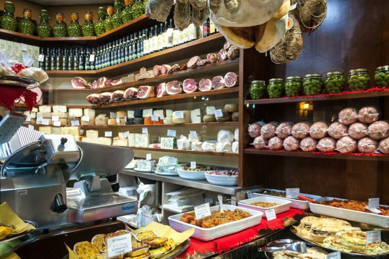 Best food tours in Bologna: a salumeria counter with cheeses, cured meats and fresh pasta
