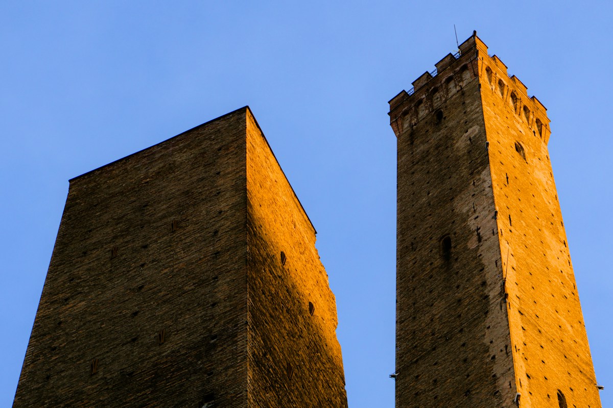 The Two Towers of Bologna against a blue sky, the first stop on a Bologna itinerary