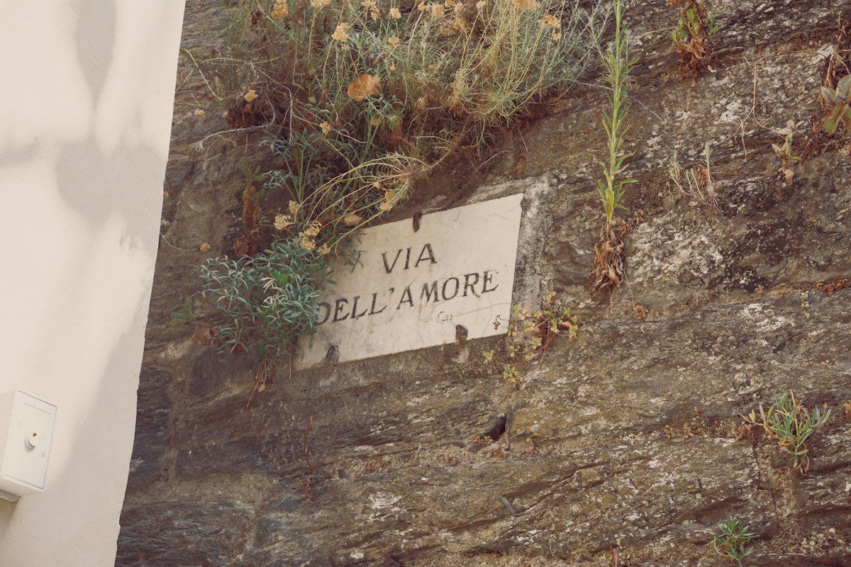Cinque Terre hiking: a sign on a stone wall in Riomaggiore