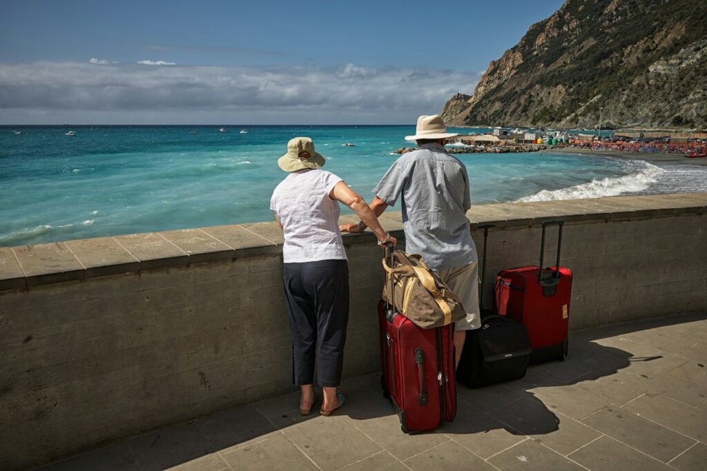 Travelers with suitcases on the Monterosso seafront at the start of a Cinque Terre itinerary