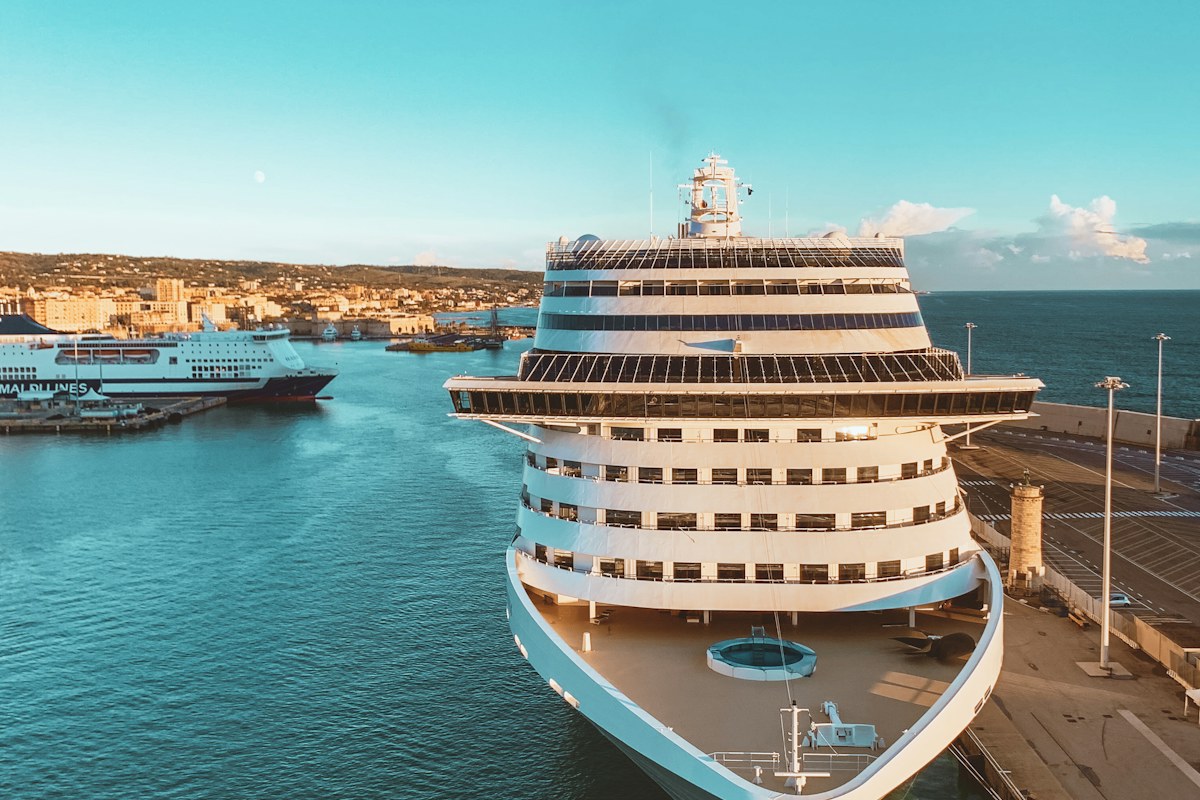 Cruise ship moored in port next to a ferry, seen from above