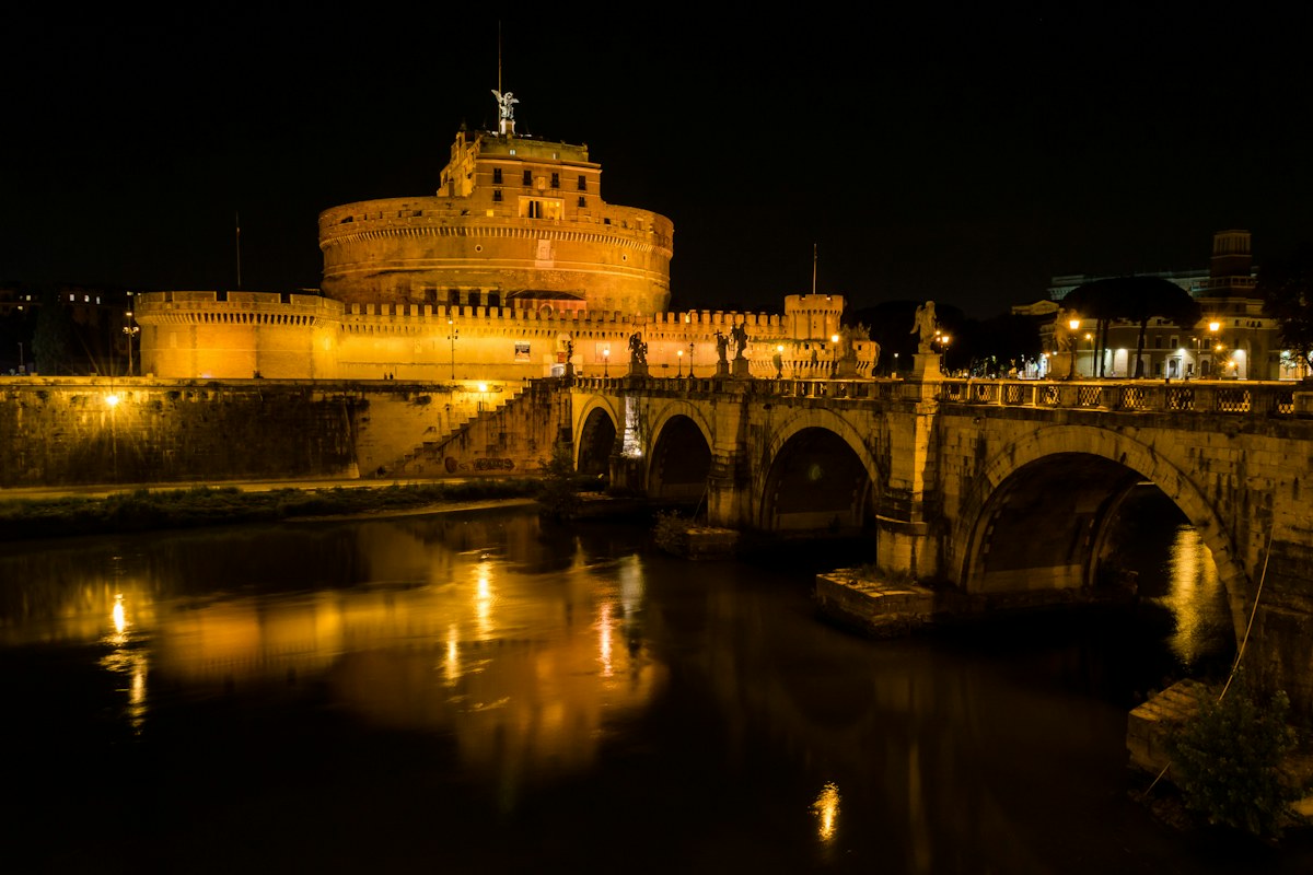 Castel Sant'Angelo reflected in the Tiber at night, a classic stop on ghost tours in Italy