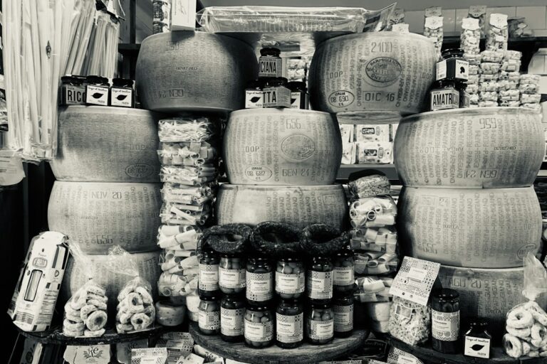 Italian cheese: stacked Parmigiano Reggiano wheels in a food shop in Naples