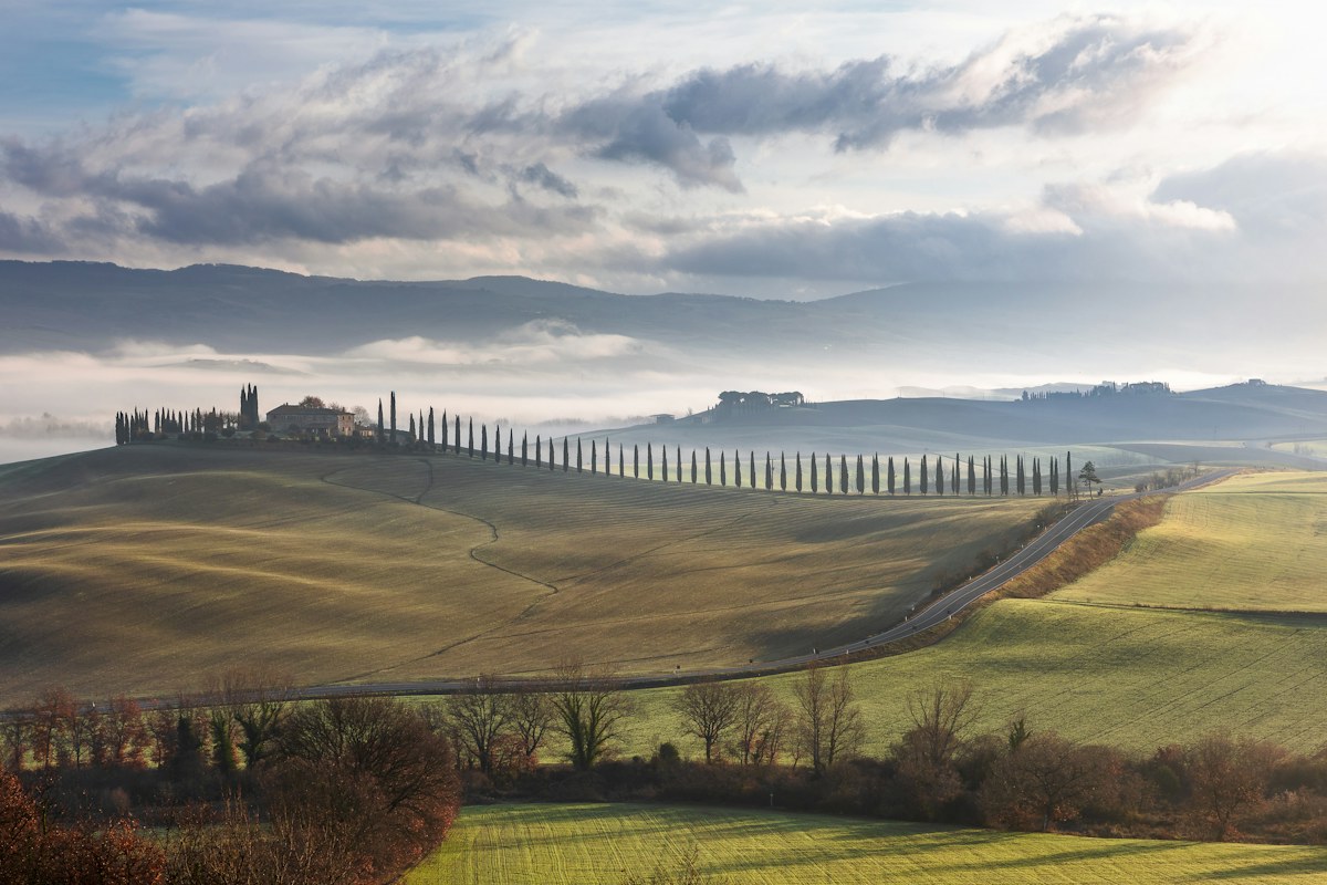 Italy in November: morning mist over the hills of Val d’Orcia near San Quirico, Tuscany