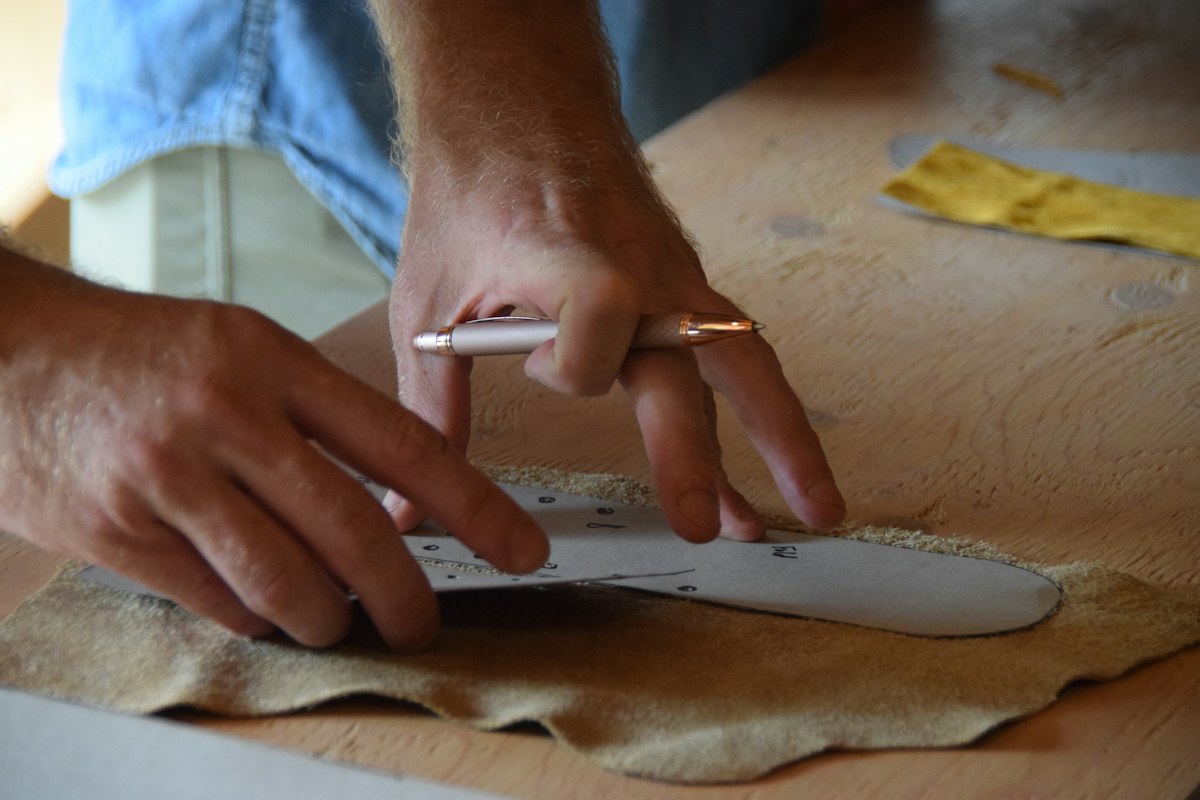 Artisan hands tracing a pattern, the craft behind the made in Italy meaning