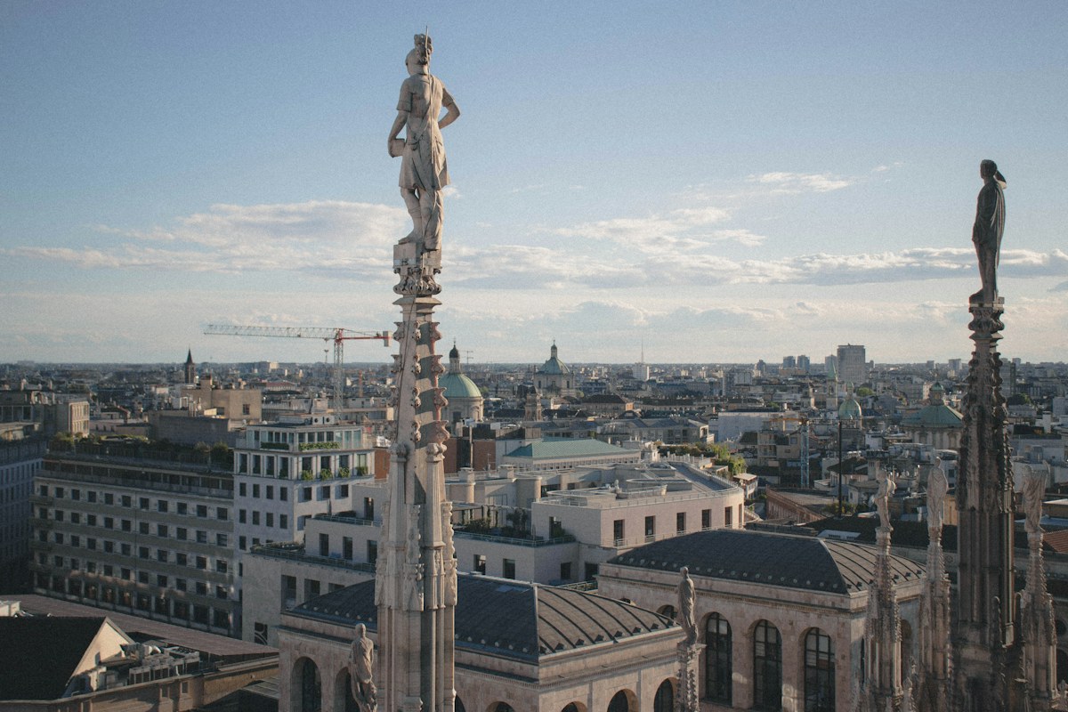Marble spires and the Milan skyline seen from the Duomo terraces