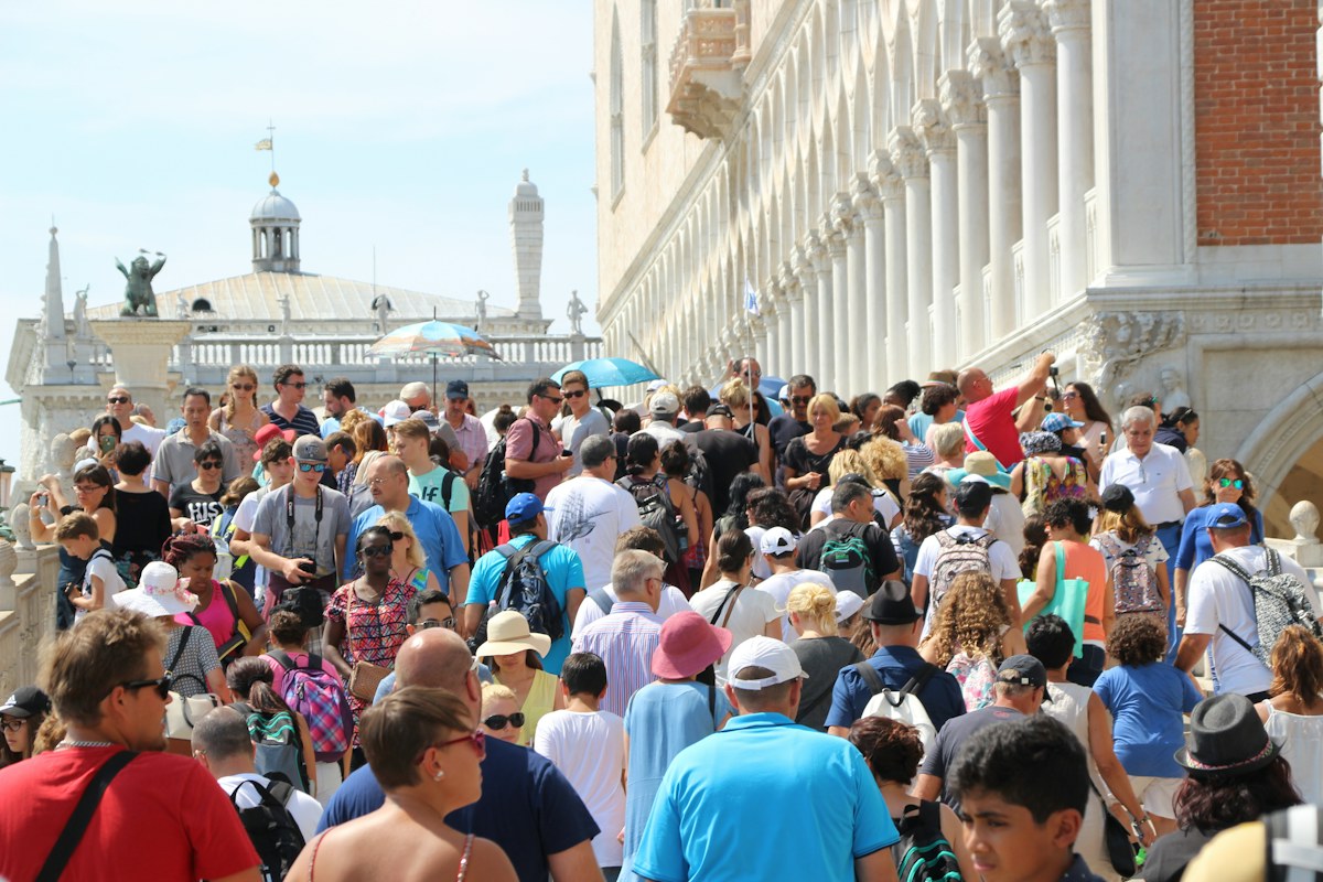 Crowds on a bridge in Venice, a symbol of overtourism in Italy
