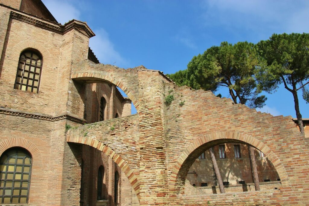Early medieval brick church walls and arches in Ravenna under a blue sky