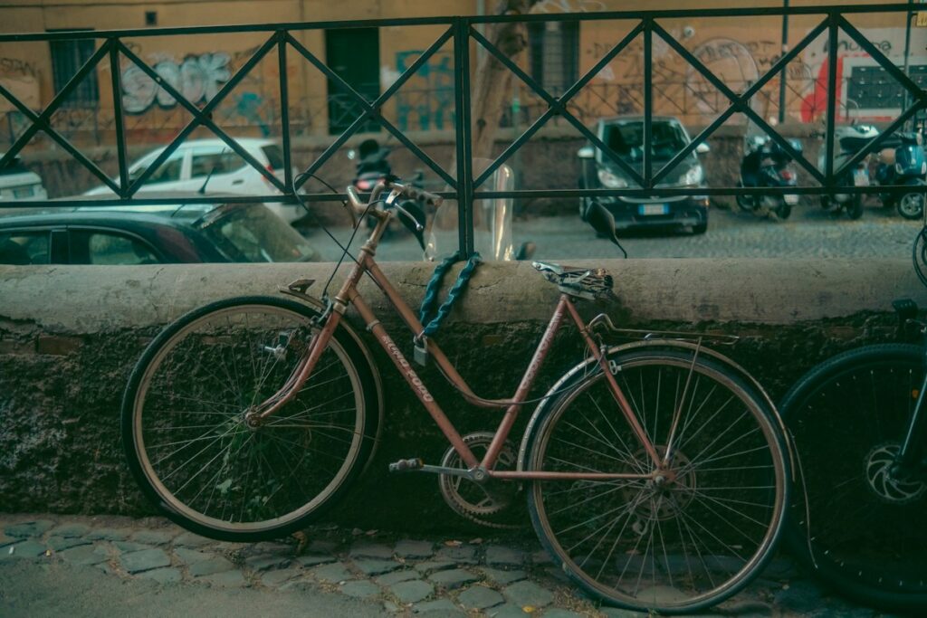 A bicycle parked by a wall on a street in Rome