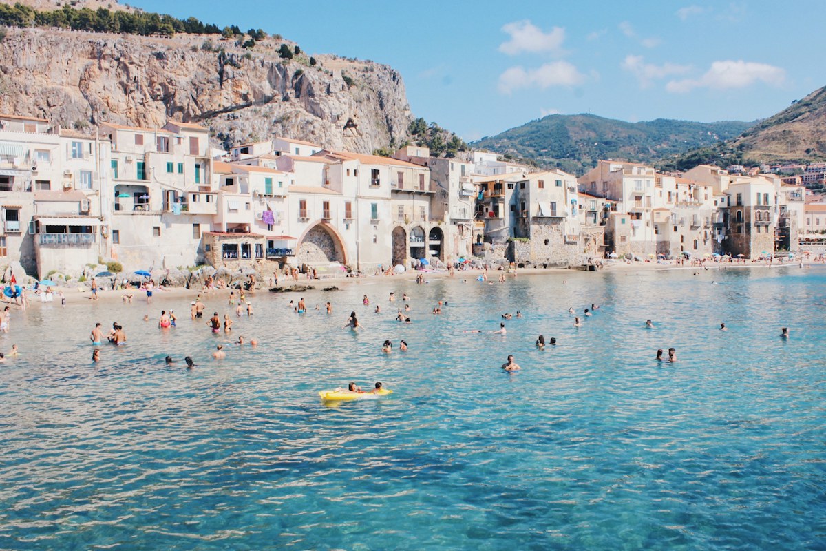 Clear water and a town beach in Sicily, a stop on a Sicily itinerary