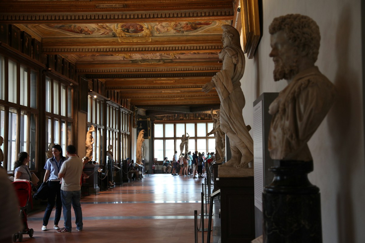 Visitors in a sculpture corridor of the Uffizi Gallery, where Uffizi tickets can be timed