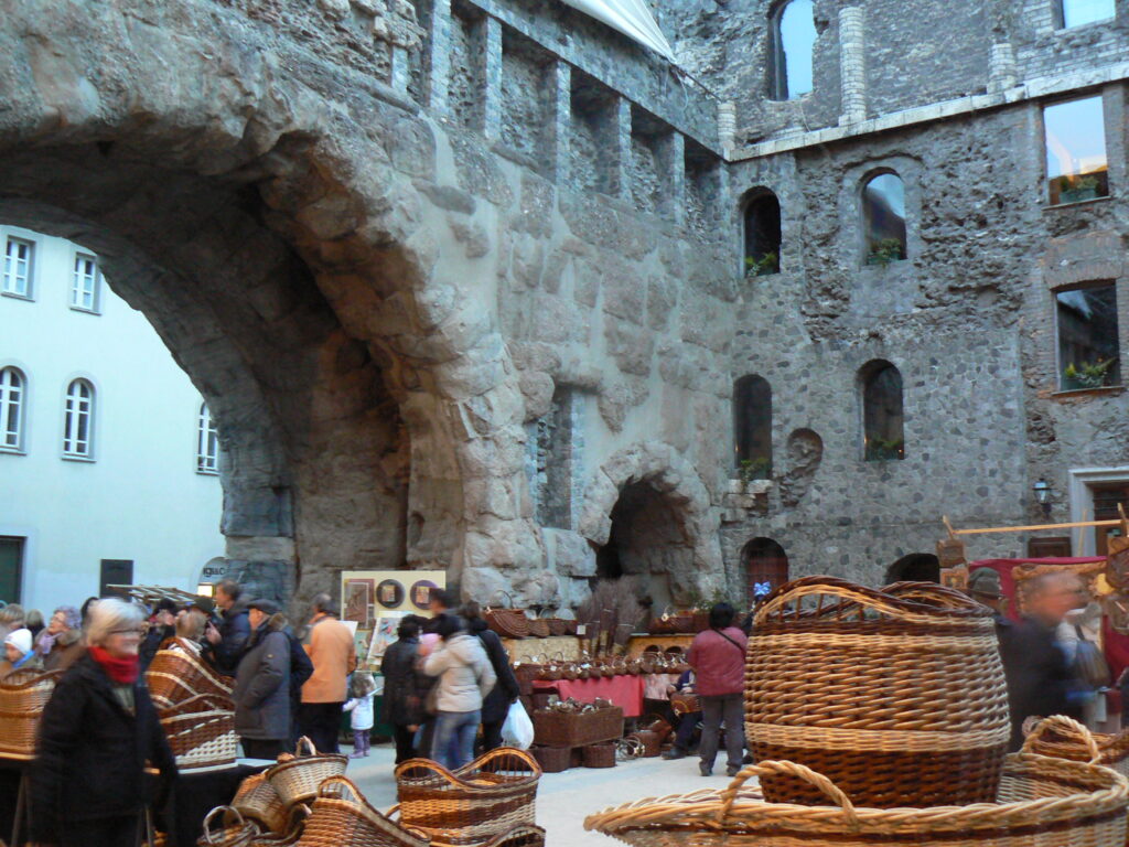 Craft stalls and visitors at Fiera di Sant Orso beside Porta Praetoria in Aosta in January 2013