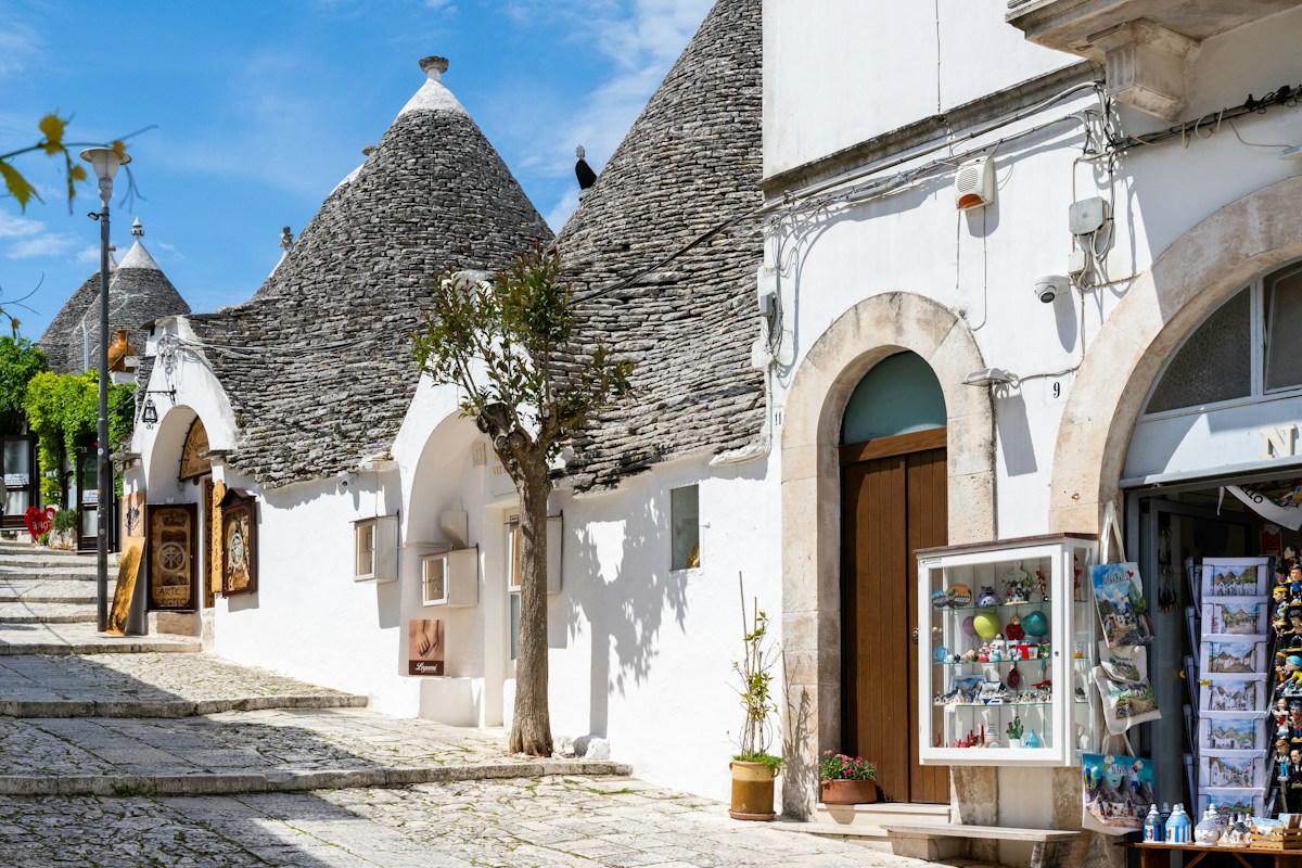 Traditional trulli along a street in Alberobello on a Valle d’Itria itinerary