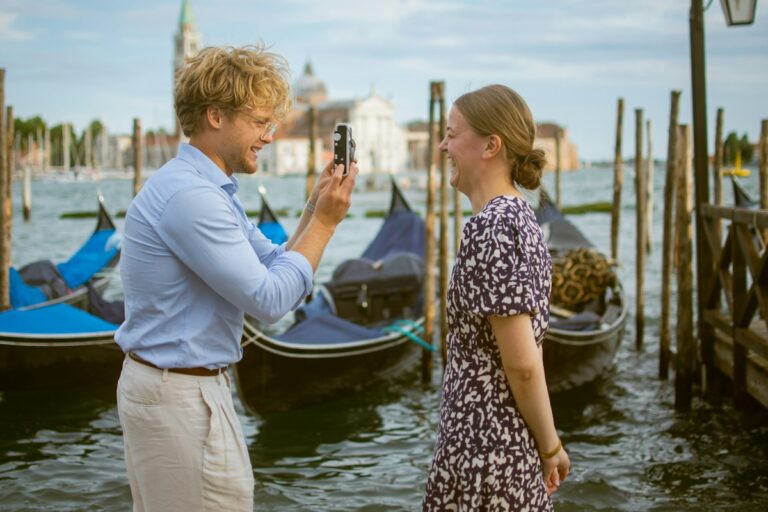 Photographer shooting a portrait by the gondolas in Venice, a classic place to propose in Italy
