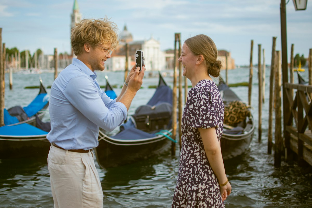 Photographer shooting a portrait by the gondolas in Venice, a classic place to propose in Italy